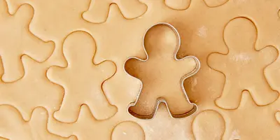 Cookie dough and a cookie cutter in the form of a gingerbread figure